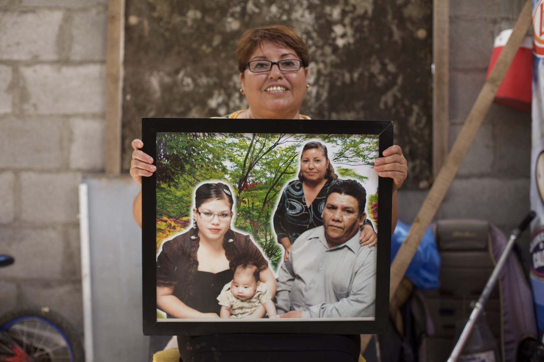 Emilia Fernández Vásquez holding a family portrait with her daughter Marlene