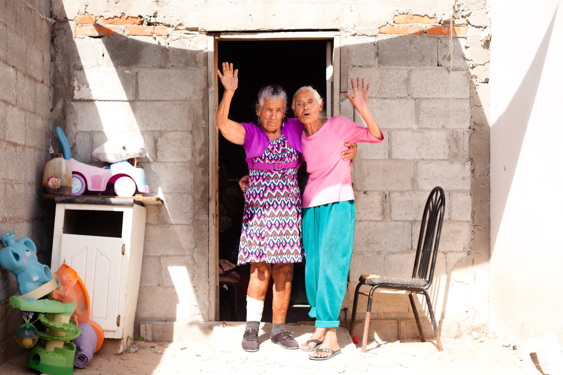 Two of the mothers waving from a doorway in Ciudad Juárez