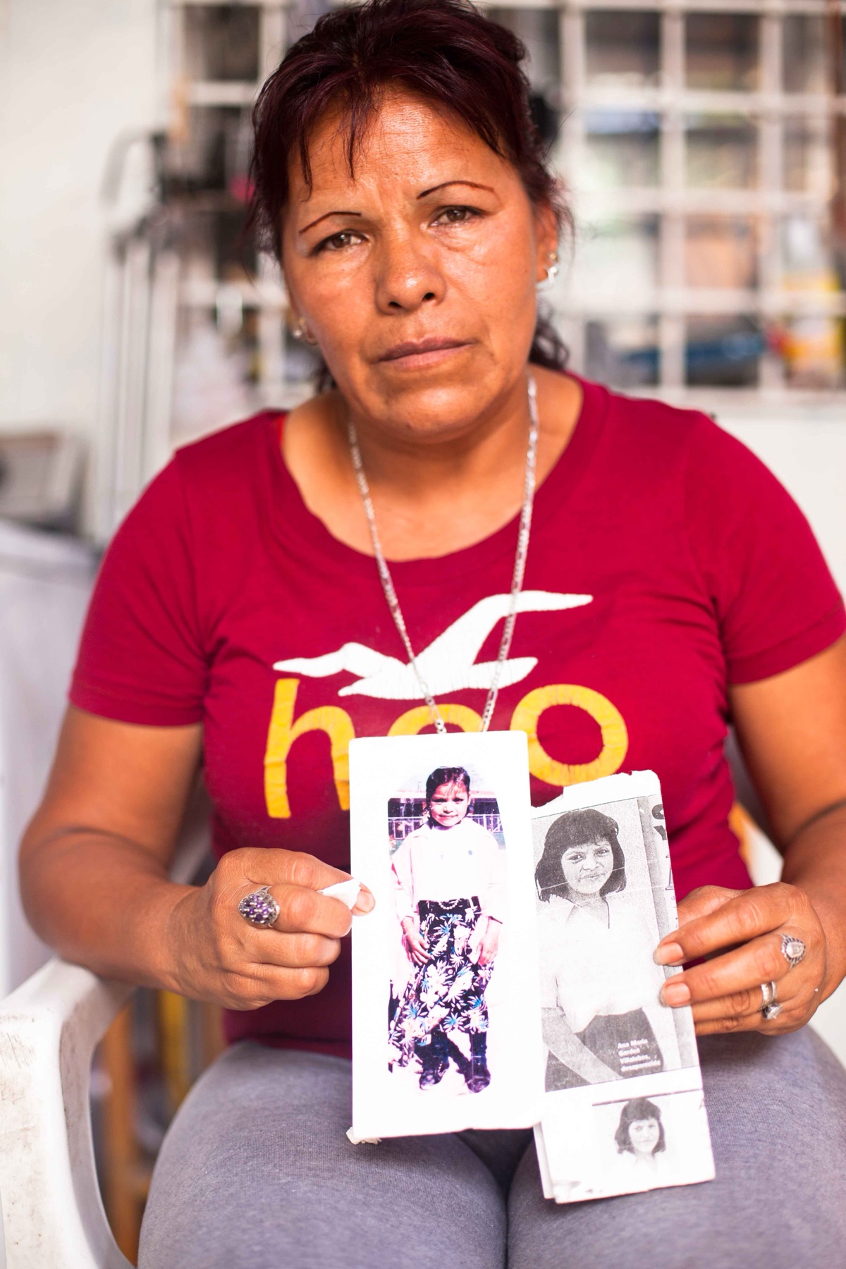 Juana Villalobos Castro holding photographs of her daughter Ana María