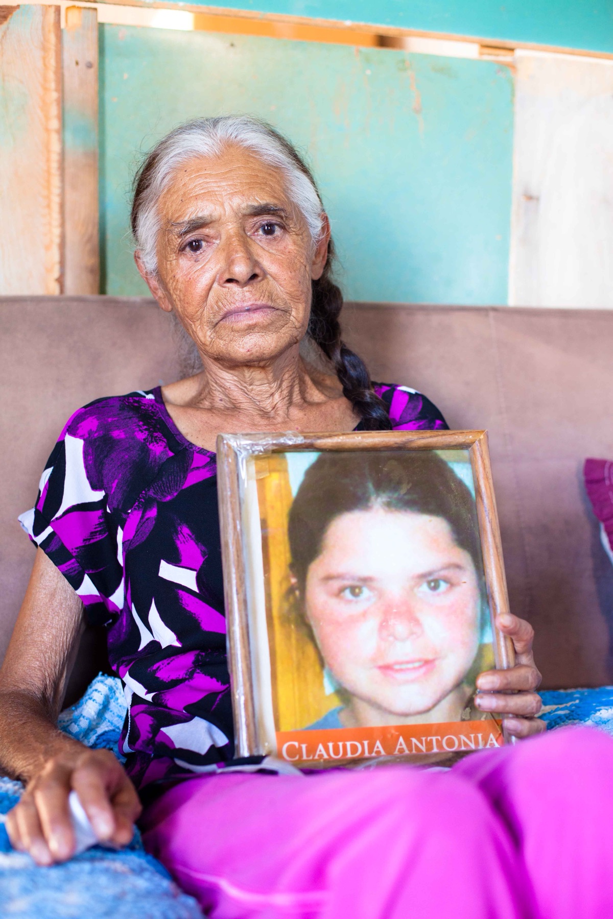 Doña Modesta holding a portrait of her daughter Claudia Antonia