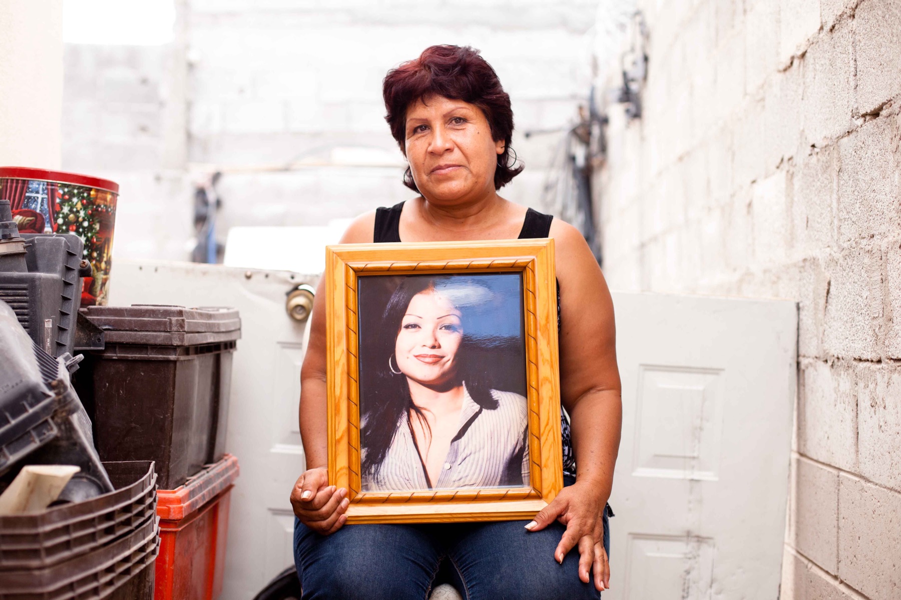 Norma Leticia Rivera Rivas holding a portrait of her daughter Flor Fabiola